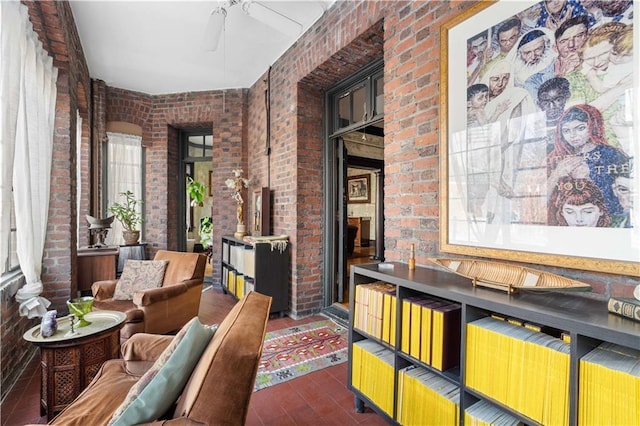 living area with dark wood-type flooring and brick wall