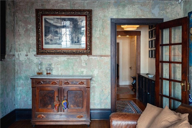 living area featuring wood finished floors and wallpapered walls