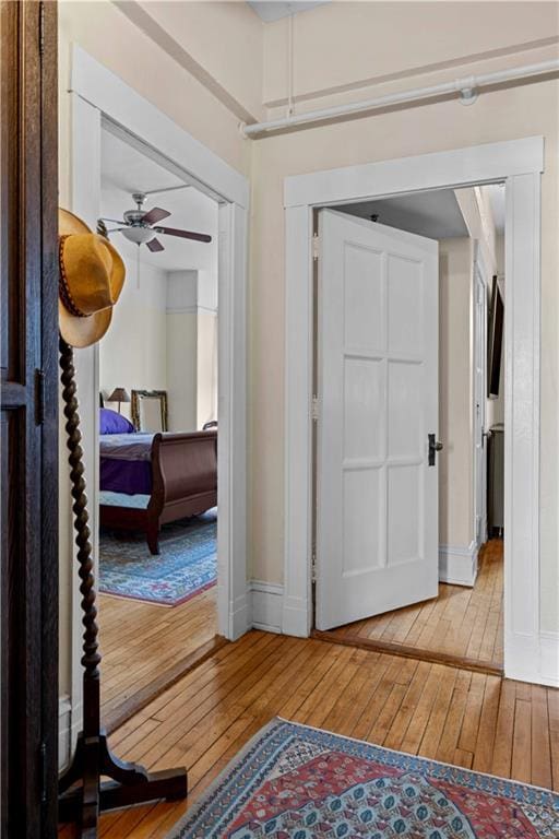 interior space with baseboards, ceiling fan, and light wood finished floors