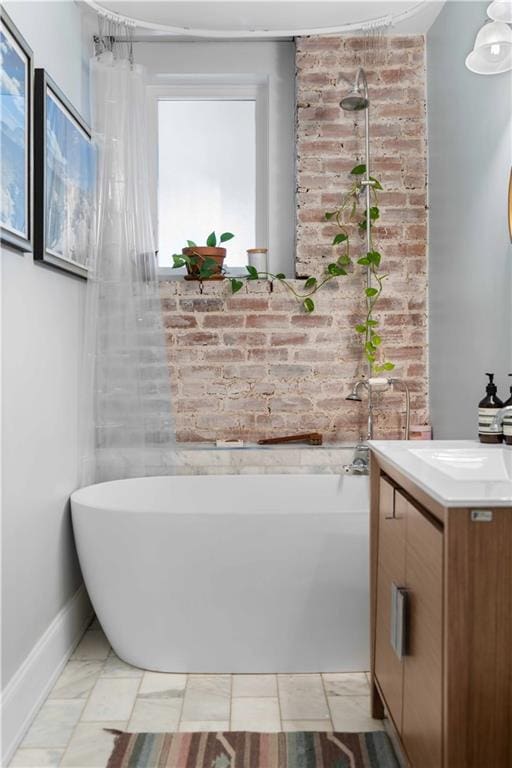 full bathroom with a freestanding bath, vanity, and baseboards