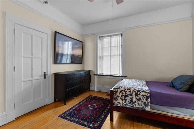 bedroom with ceiling fan, baseboards, and hardwood / wood-style flooring