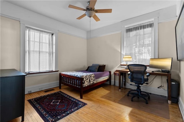 bedroom featuring visible vents, hardwood / wood-style flooring, and baseboards