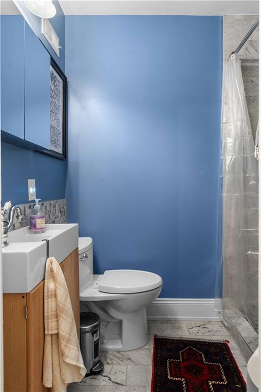 full bathroom featuring baseboards, toilet, curtained shower, marble finish floor, and vanity