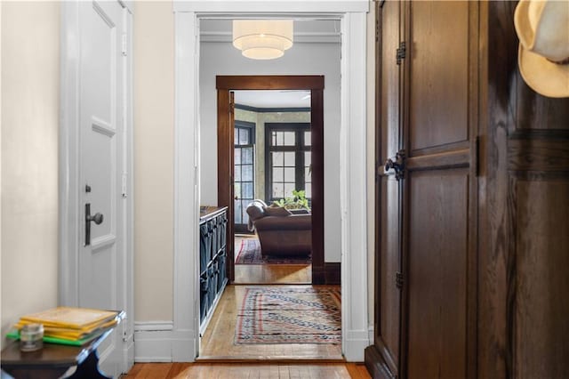 interior space with ornamental molding, baseboards, and light wood finished floors