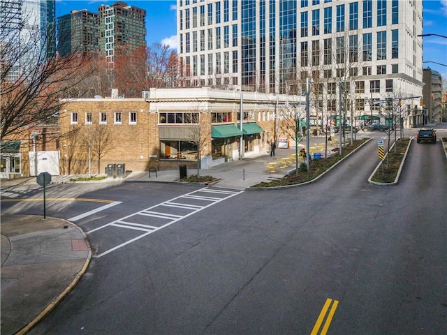 exterior space featuring street lighting, a city view, curbs, and sidewalks