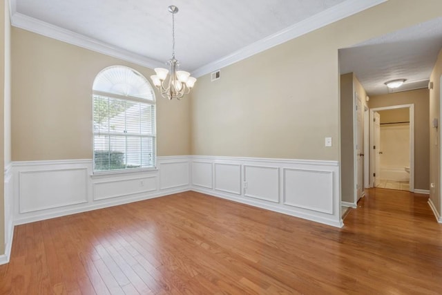 2410 Napa Valley Dr, Villa Rica, GA 30180 - unfurnished room with a chandelier, light wood finished floors, wainscoting, and ornamental molding