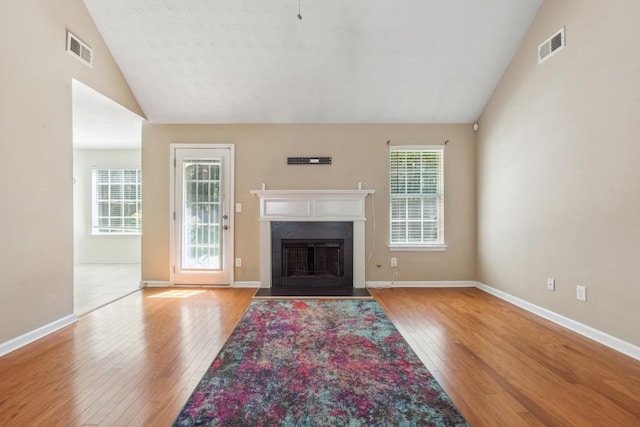 2410 Napa Valley Dr, Villa Rica, GA 30180 - unfurnished living room featuring lofted ceiling, hardwood / wood-style flooring, and a fireplace with flush hearth