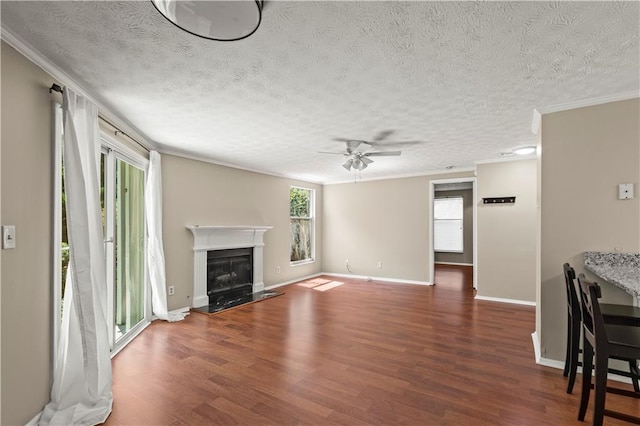 living room with dark hardwood / wood-style flooring, crown molding, a wealth of natural light, and a high end fireplace