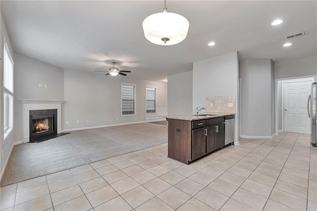 kitchen featuring pendant lighting, light carpet, ceiling fan, appliances with stainless steel finishes, and dark brown cabinets