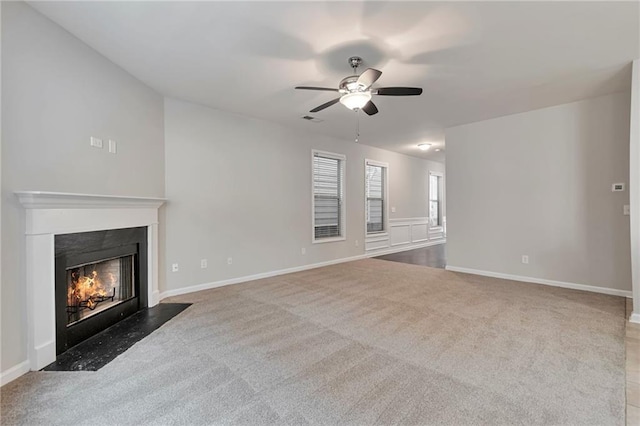 unfurnished living room featuring ceiling fan and carpet floors