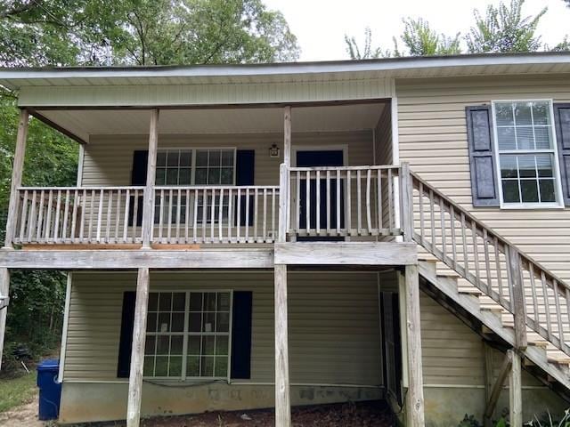 rear view of property with stairs and covered porch