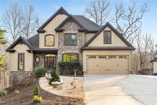 craftsman-style house with stone siding, roof with shingles, board and batten siding, and driveway