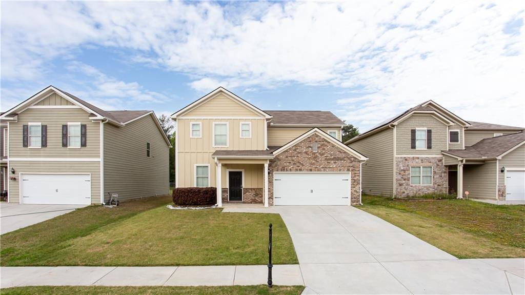 7747 Rudder Cir, Fairburn, GA 30213 - craftsman-style house with concrete driveway, a front lawn, board and batten siding, and brick siding