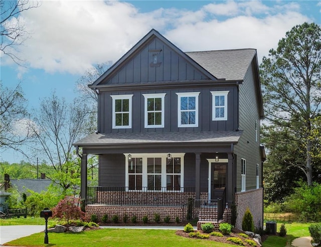craftsman house with a porch, board and batten siding, a shingled roof, and a front yard