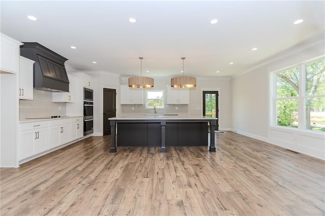 kitchen with light countertops, black electric cooktop, built in microwave, tasteful backsplash, and double wall oven