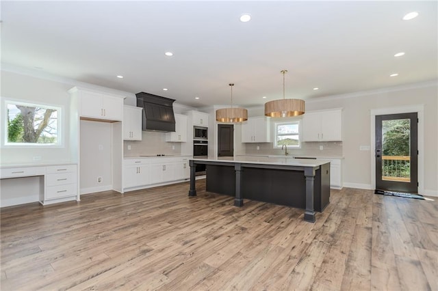 kitchen featuring light countertops, white cabinetry, stainless steel microwave, and a sink