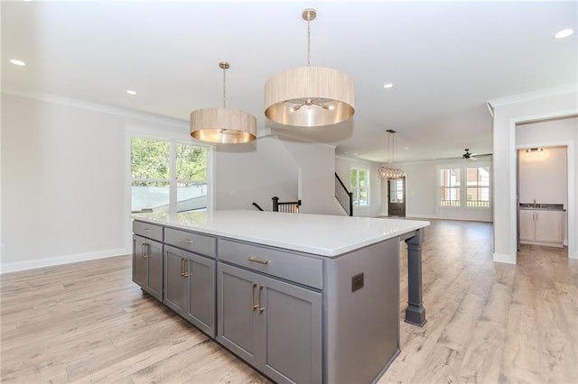 kitchen with plenty of natural light, ornamental molding, baseboards, and gray cabinetry