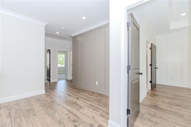 hallway with crown molding, recessed lighting, baseboards, and light wood finished floors