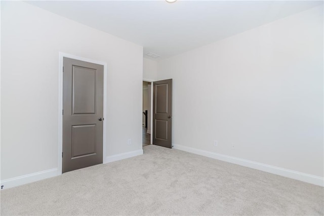 carpeted spare room featuring baseboards