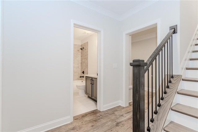 staircase featuring baseboards and wood finished floors