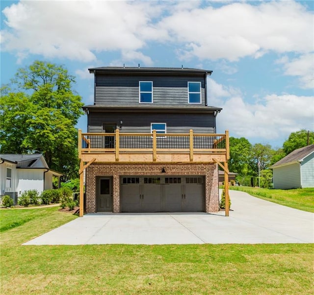 back of house with a garage, a yard, a wooden deck, and concrete driveway