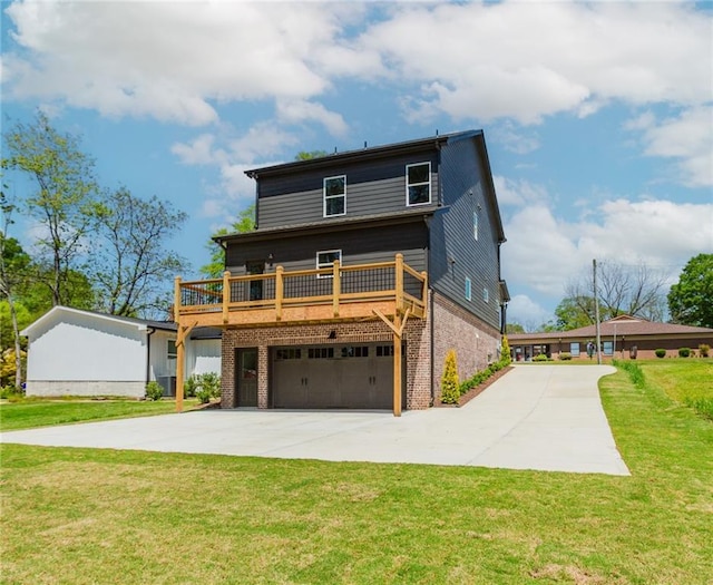 rear view of property featuring driveway, a deck, a garage, brick siding, and a yard