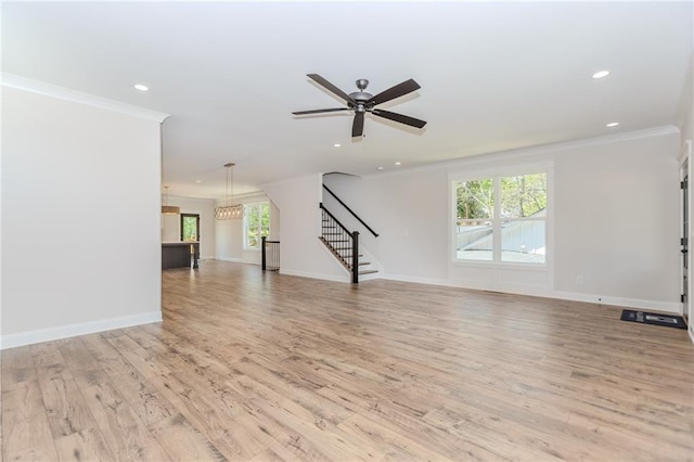 unfurnished living room featuring crown molding, recessed lighting, plenty of natural light, and stairway
