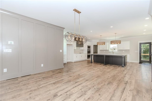 kitchen with decorative backsplash, recessed lighting, light countertops, light wood finished floors, and appliances with stainless steel finishes