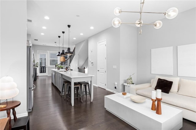 living room with sink, a chandelier, and dark hardwood / wood-style floors