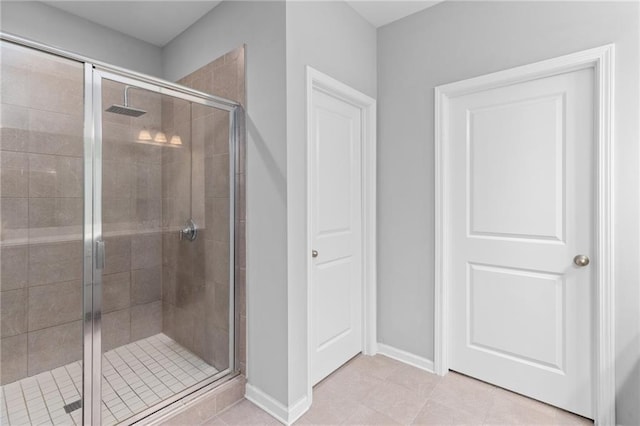 bathroom featuring a shower with door and tile patterned flooring