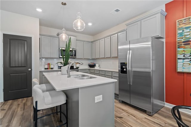 kitchen featuring stainless steel appliances, gray cabinets, light countertops, and recessed lighting