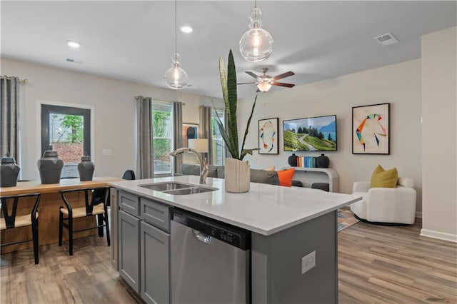 kitchen with dishwasher, a sink, gray cabinets, open floor plan, and light wood finished floors