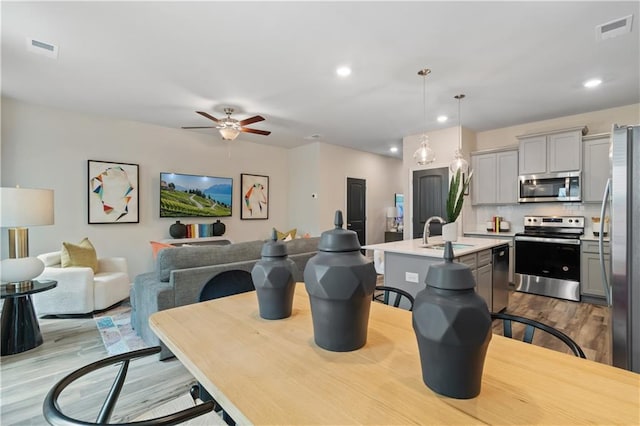 dining space with light wood-style floors, ceiling fan, and recessed lighting