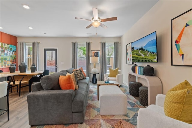 living area featuring ceiling fan, light wood-style floors, recessed lighting, and baseboards