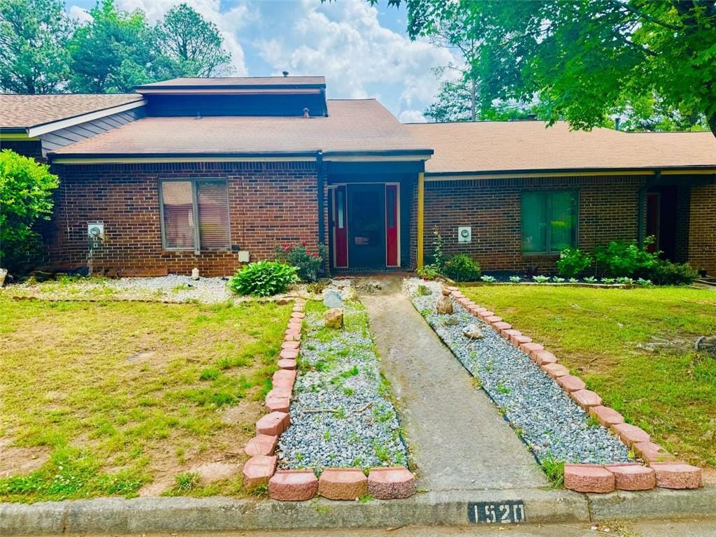 view of front of home featuring brick siding and a front yard