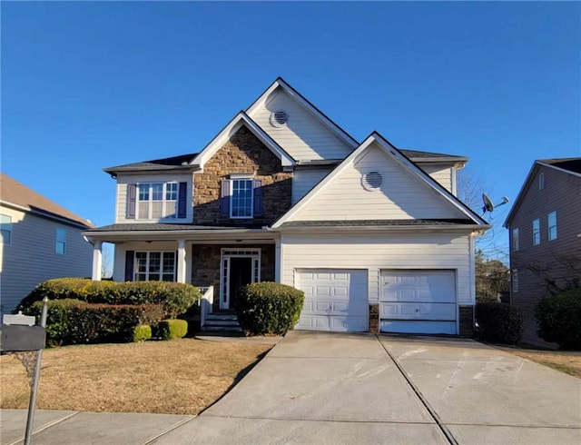 view of front of house featuring stone siding, an attached garage, and driveway