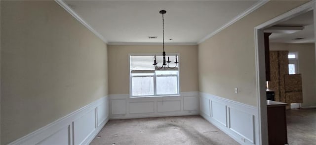 unfurnished dining area featuring a wainscoted wall, ornamental molding, and a decorative wall