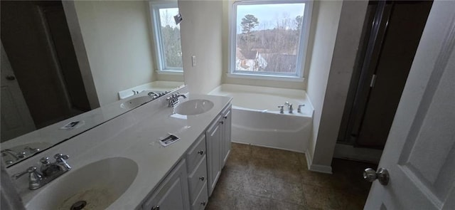 full bathroom featuring a sink, double vanity, and a garden tub