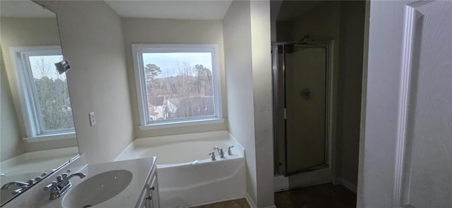 full bathroom with a wealth of natural light, a garden tub, vanity, and a shower stall