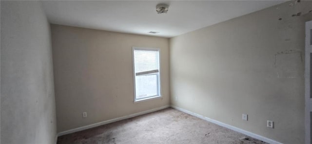 spare room with light carpet, visible vents, and baseboards