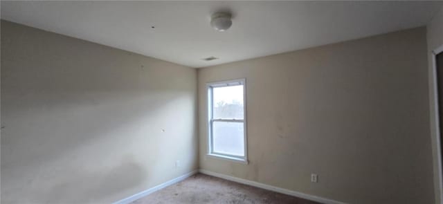 unfurnished room with baseboards and light colored carpet