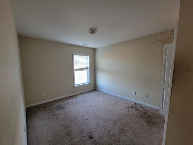 carpeted empty room with visible vents and baseboards