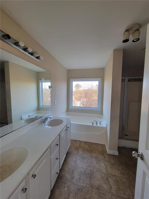 full bath with a garden tub, double vanity, a sink, and a shower stall