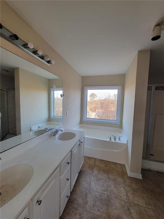 bathroom featuring double vanity, a sink, and a bath