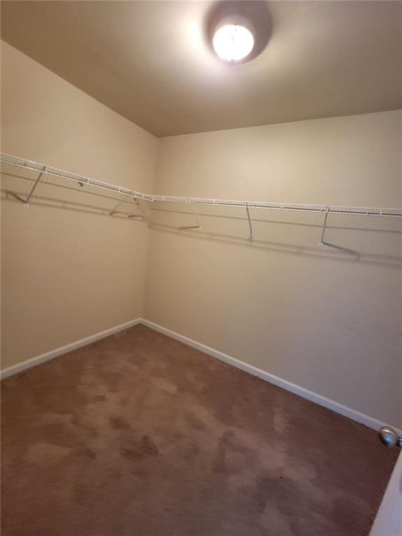 spacious closet with dark carpet