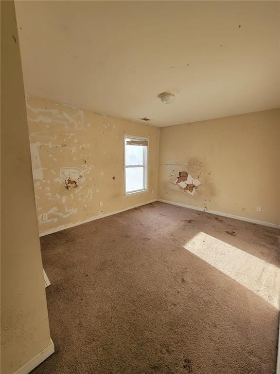 unfurnished room featuring carpet floors and baseboards