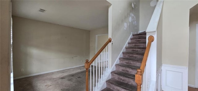 stairs featuring visible vents, carpet flooring, and wainscoting