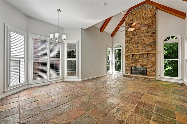 unfurnished living room with a wealth of natural light, a stone fireplace, and beamed ceiling