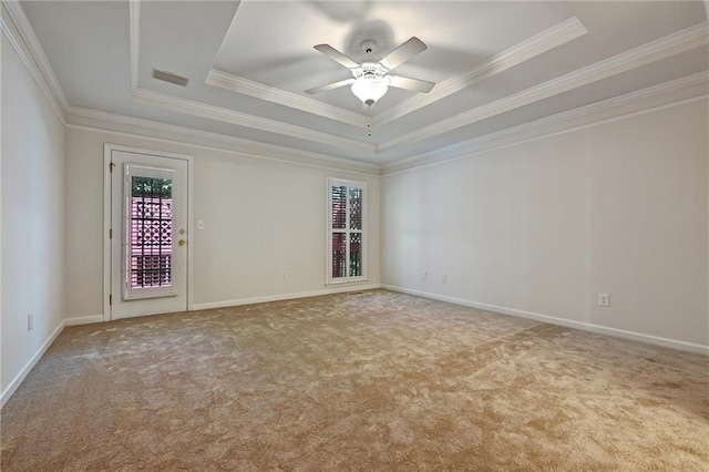 carpeted empty room featuring ceiling fan, a raised ceiling, and crown molding