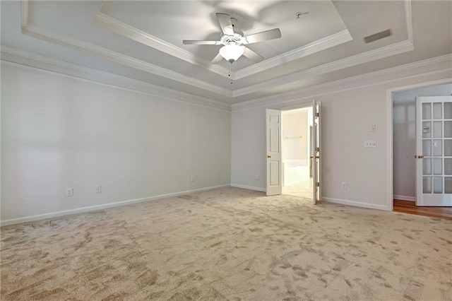 unfurnished bedroom with a tray ceiling, ceiling fan, and ornamental molding